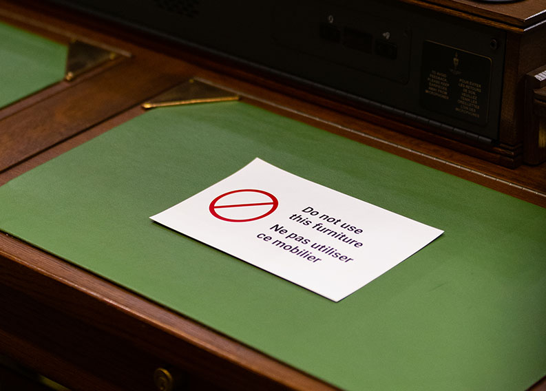 Photo of signage on a Member’s desk to ensure compliance with physical distancing guidelines