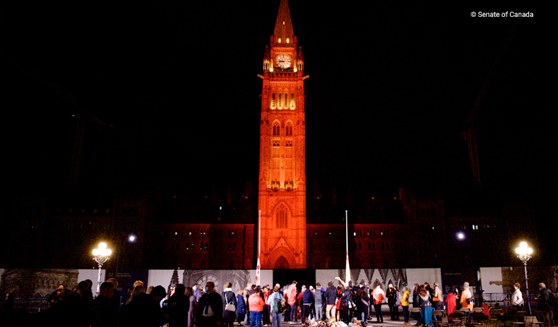 The Peace Tower on Parliament Hill is illuminated orange