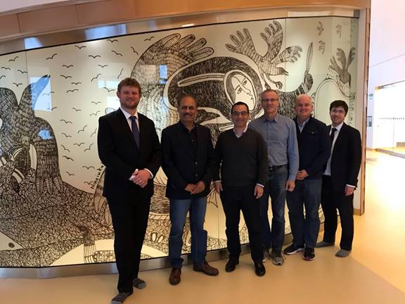 Figure 24 is a photo of Members of the Foreign Affairs Committee standing next to Indigenous artwork inside the Canadian High Arctic Research Station in Cambridge Bay.