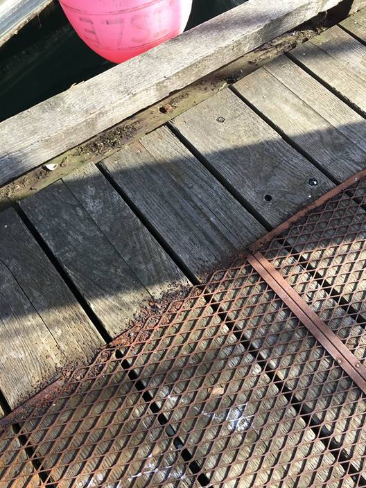 Rusted metal gratings that were recently repaired at the core fishing harbour in Bella Bella, British Columbia